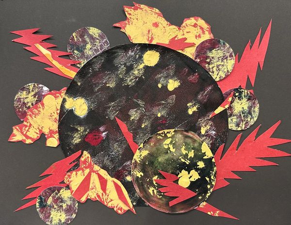 Brown mat board with large speckled black circle surrounded by red lightning-like shapes and ochre a
