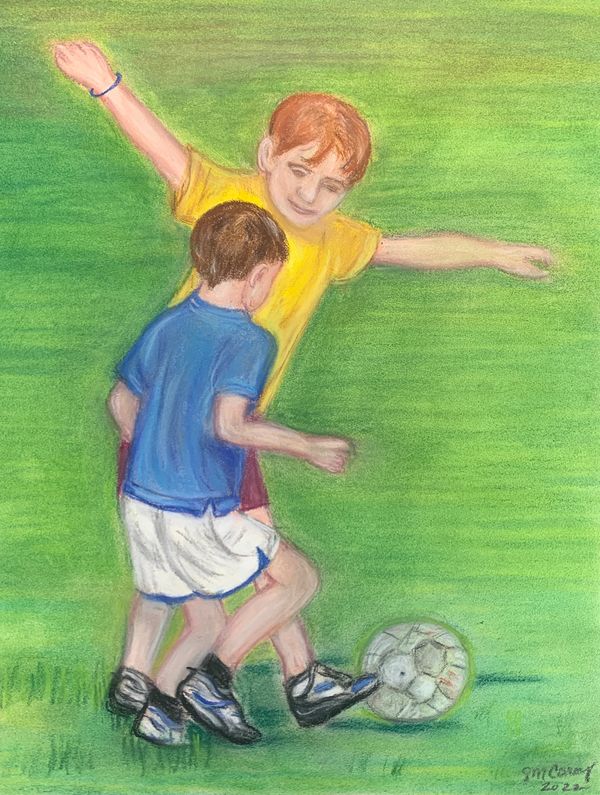 Two young boys kicking soccer ball on grass.