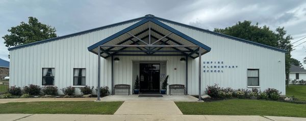 Entrance of Umpire Elementary School with benches and greenery.