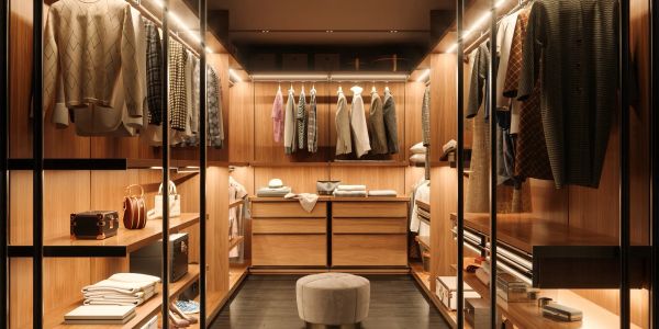 Luxurious walk-in closet with warm lighting and organized clothing.