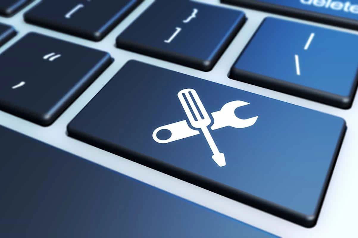Keyboard key with screwdriver and wrench icons symbolizing tools.