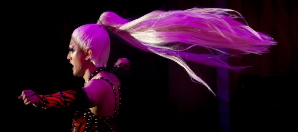 Performer with long pink hair in motion.