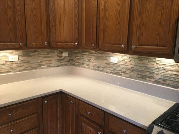 Completed tile back splash with under cabinet lights.