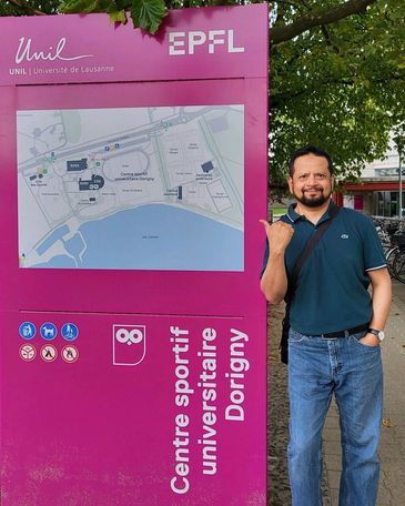 Standing before the sign of Switzerland's École Polytechnique Fédérale de Lausanne (EPFL),