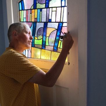 Installing a contemporary stained glass window that has been triple glazed into an old front door.