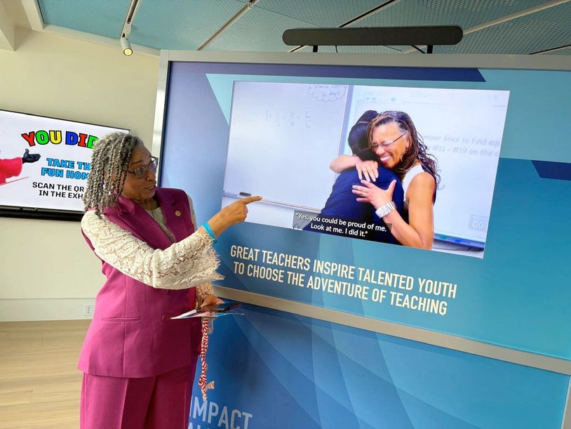 Woman pointing at an inspirational teaching display.