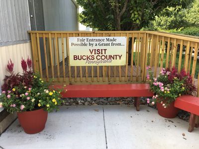 Bench with flower pots and a sign about Bucks County grant.