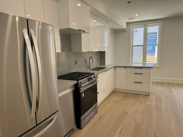 Modern kitchen with stainless steel appliances and white cabinets.