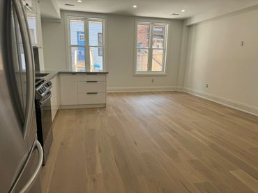 Modern kitchen with stainless steel appliances and light wood flooring.