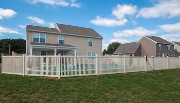 White vinyl fence surrounding a backyard pool.