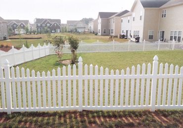 White picket fence in a suburban backyard.