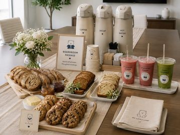 Meeting table with snacks, drinks, and coffee setup.