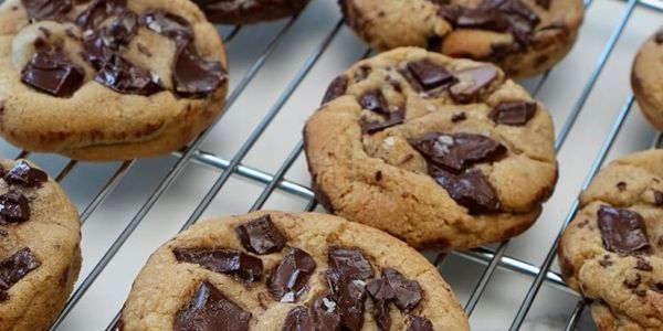 Freshly baked chocolate chip cookies cooling on a rack.