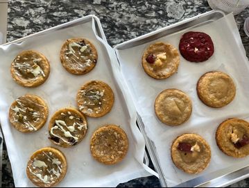 Two trays of assorted cookies on parchment paper.