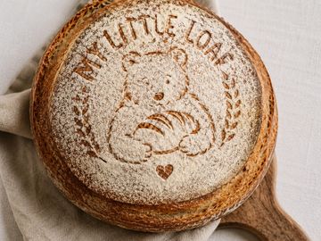 Artistic bread with a bear and 'My Little Loaf' inscription.