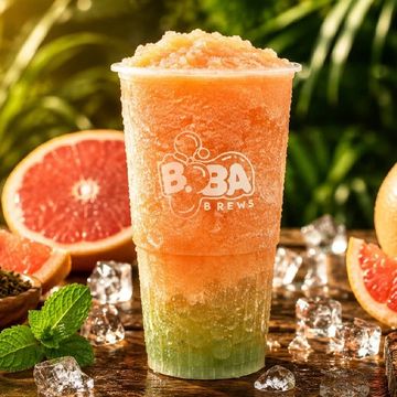 Colorful layered boba drink with grapefruit and mint garnish.