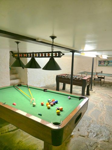 Full view of the entire games room with pool table in the front, table football and table tennis.