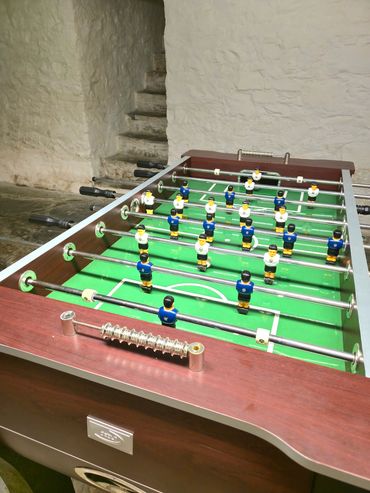 Table football the primary focus with stairs in the background leading up to the ground floor.