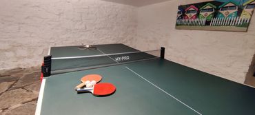 Table tennis set up with bats and balls ready for action.