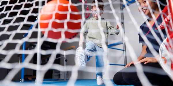 Child with disability playing soccer in intensive physiotherapy