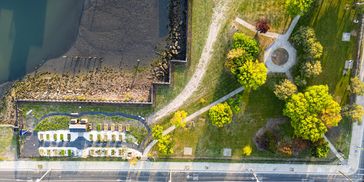 Aerial view of a waterfront park with greenery and pathways.