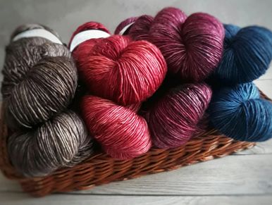 Colorful skeins of yarn neatly arranged in a basket.