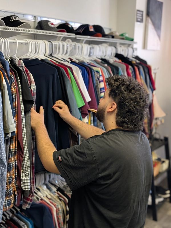 Young man looking through shirt rack