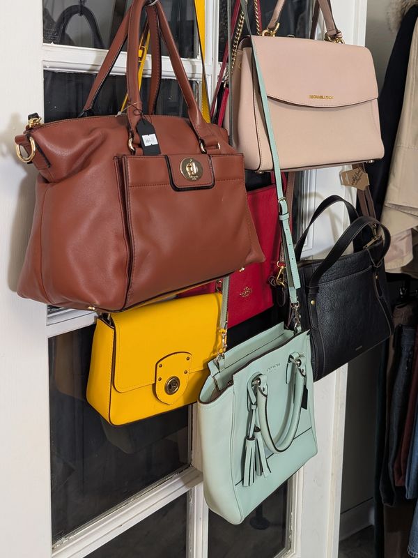 Stylish purses hanging on a door