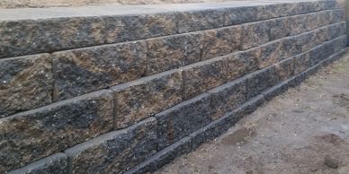 Block style retaining wall with French drain and gravel backfill