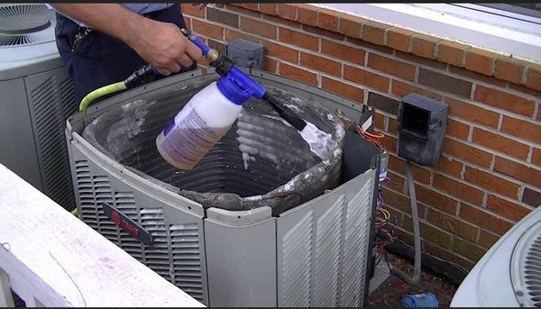 HVAC technician doing routine maintenance on air conditioning system in customer home in Arizona.