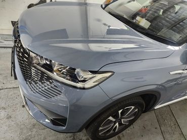 Close-up of a car's front corner in a garage.