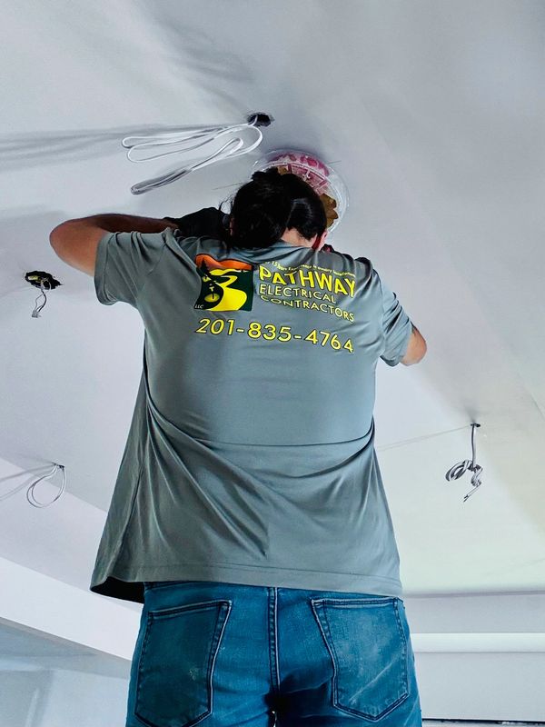Electrician cutting holes in ceiling for Recessed lighting.