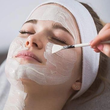 Woman receiving a facial mask treatment.