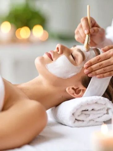 Woman receiving a facial mask treatment at a spa.