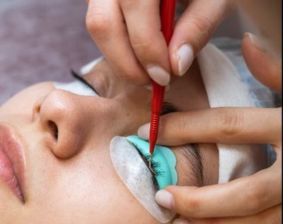 Close-up of eyelash extension application on a woman's eye.