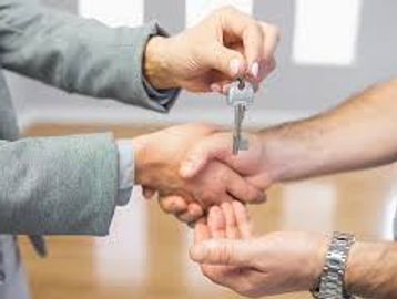 A realtor handing over the keys to the home buyers new home