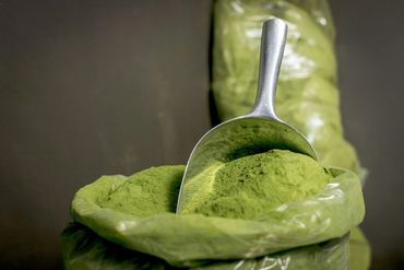 Green powder in a plastic bag with a metal scoop.