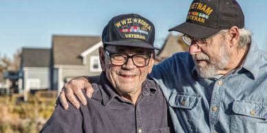 Two men wearing veteran caps