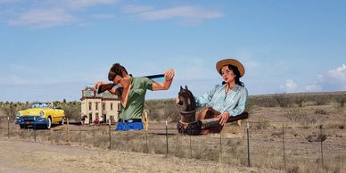 A roadside with large cutouts of a man and a woman