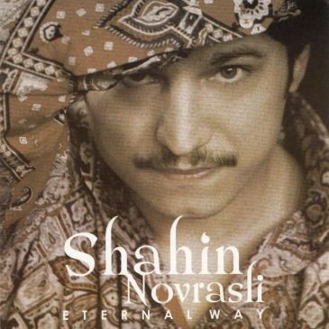 Portrait of a man with a patterned bandana and mustache.