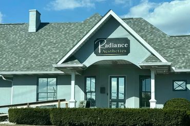 Radiance Aesthetics building with a gray roof and clear blue sky.