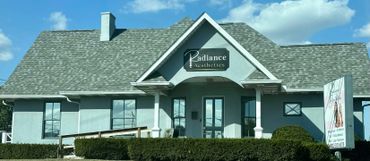 Radiance Aesthetics building with a gray roof and clear blue sky.