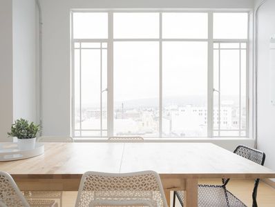 Bright meeting room with a large wooden table and modern chairs by a big window.