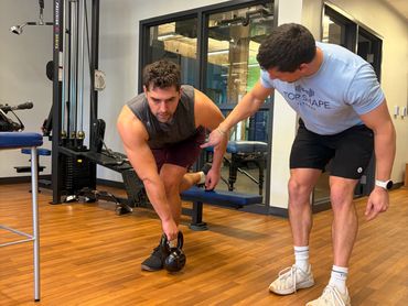 Mobility training for tennis and golf—single-leg kettlebell work at Top Shape Charleston gym.