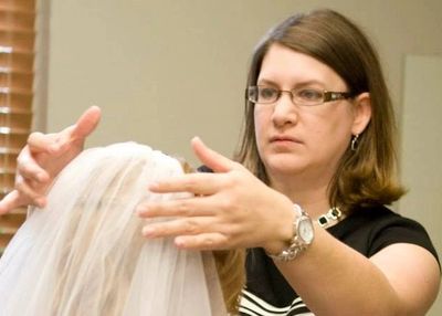Owner Michelle Bodine adjusting the veil of a bride before her wedding.