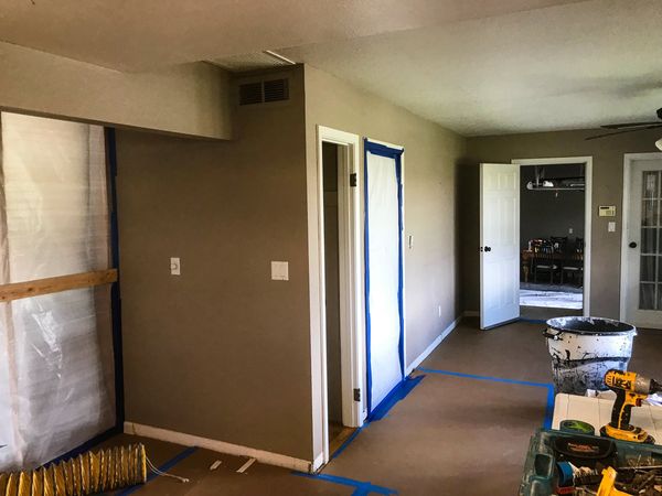 Interior renovation in progress with dust containment walls, protected flooring, temporary construct