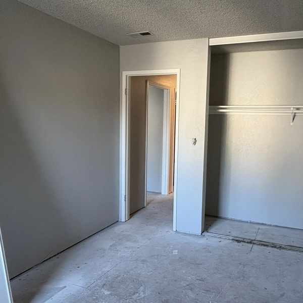 During renovation photo of Fremont bedroom remodel showing fresh paint, closet preparation, wall rep