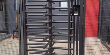 Security turnstile gate with a fingerprint scanner at an entrance.