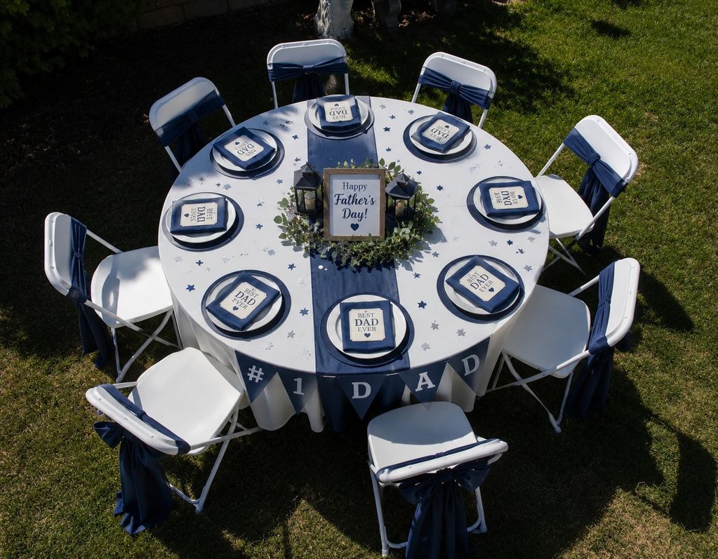 Outdoor Father's Day party table set with navy blue and white decorations.