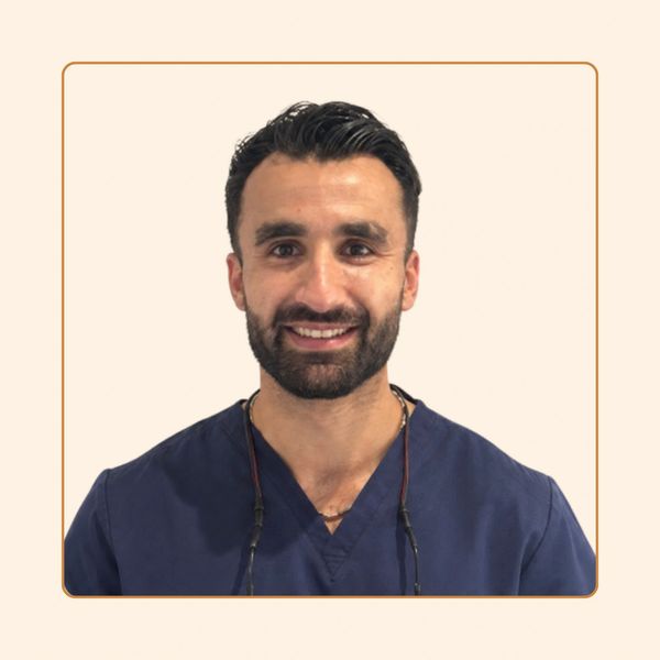 Smiling man in blue medical scrubs.
